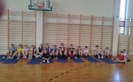dzieci i młodzież, uczestnicy zajęć lekkoatletycznych z MOSiR, siedzą w hali sportowej ZS nr 1 w Działdowie