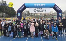 pamiątkowa fotografia dzieci dorosłych biorących udział w projekcie "Tropem Wilczym – Bieg Pamięci Żołnierzy Wyklętych". Zdjęcie zostało zrobione na stadionie działdowskiego MOSiR