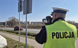 policjant mierzy prędkość przejeżdżających pojazdów na jednej z dróg w powicie działdowskim