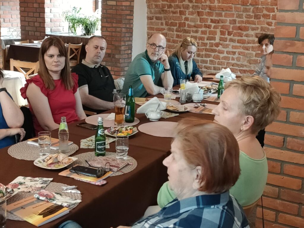 Nowe tomiki wierszy, współpraca z przytuliskiem i inne plany Działdowskiej Kuźnia Słowa kobiety i mężczyźni siedzą przy stole w Restauracji "Przedzamcze"