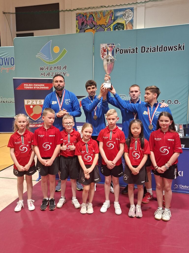 zawodnicy Dekorglass Działdowo - zdobywcy Pucharu Polski (z pucharem) i dzieci, wszyscy stoją w hali sportowej / fot. Dekorglass Działdowo