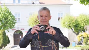 mężczyzna trzyma aparat fotograficzny druh