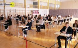 uczniowie siedzący w ławkach w sali gimnastycznej Szkoły Podstawowej nr 4 tuż przed rozpoczęciem egzaminu z języka polskiego