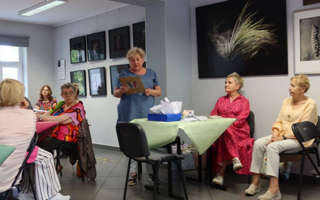 "Poezja kameralnie" na Dzień Ojca osoby siedzące przy stoliku w Miejskiej Bibliotece Publicznej w ramach wydarzenia "Poezja kameralnie"