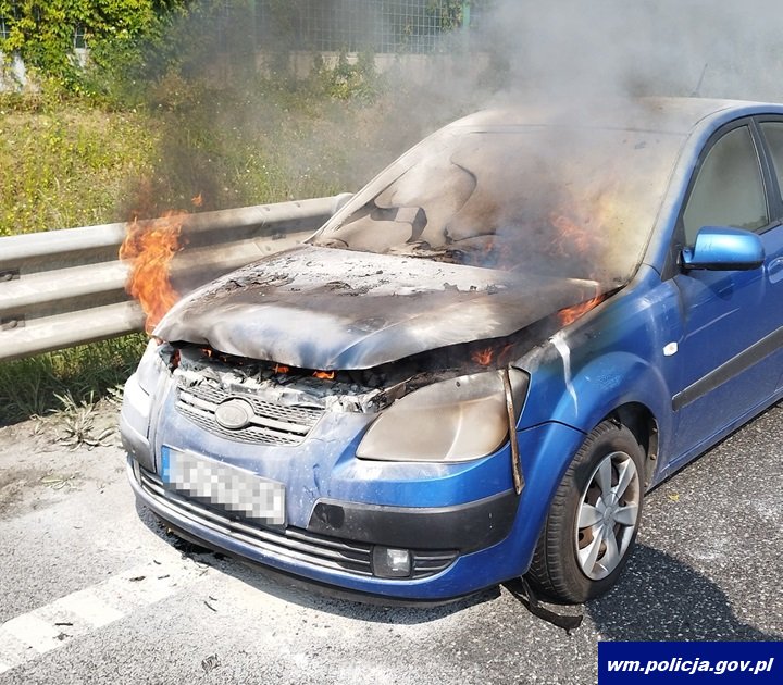 Policjanci gasili płonące auto auto w płomieniach