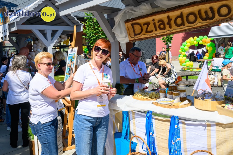 Działdowo na XVI Festiwalu Miast Cittaslow w Sianowie pod znakiem recertyfikacji i nowej inicjatywy rowerowej! stoisko promocyjne Działdowa, stoją osoby dorosłe