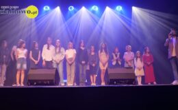 na scenie Miejskiego Domu Kultury stoją dorośli, dzieci, młodzież