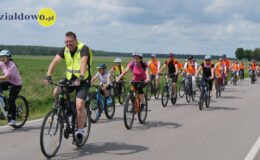 grupa osób jedzie na rowerach drogą