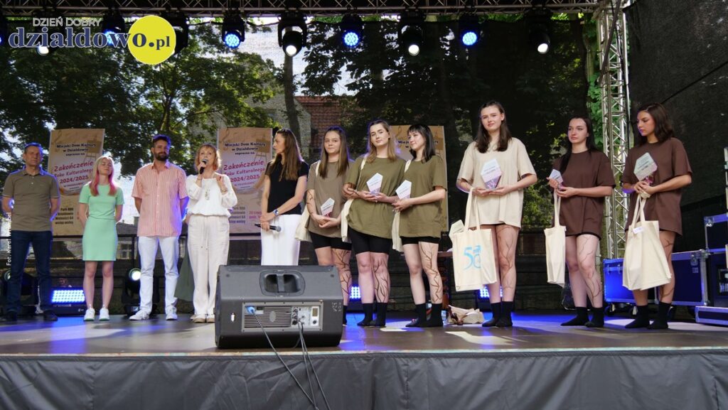 na scenie stoją osoby dorosłe i młodzież