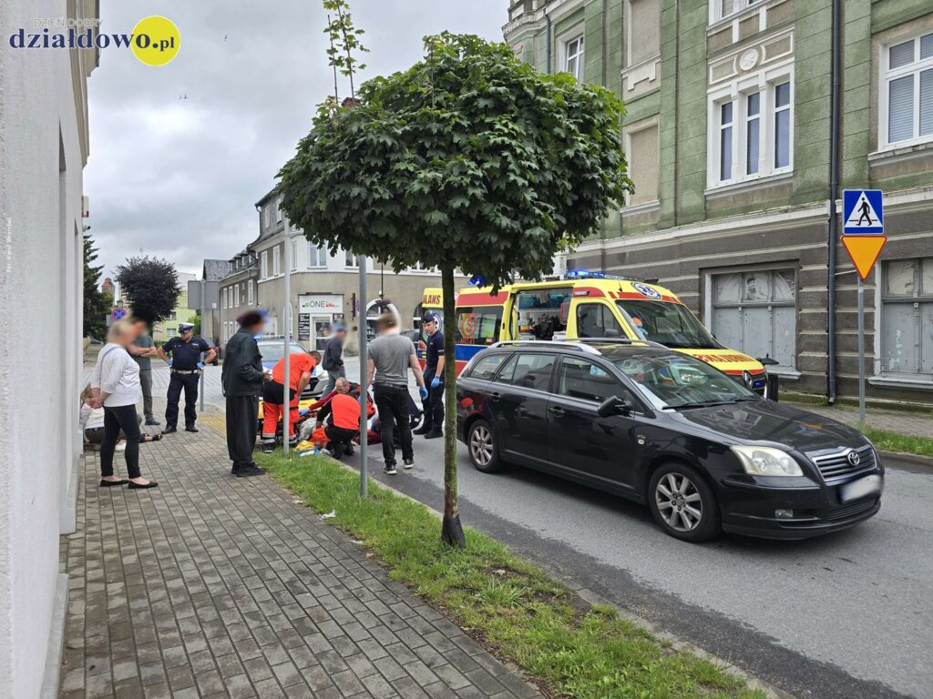 Potrącenie pieszej na pasach moment udzielania pomocy poszkodowanej przez służby ratunkowe, widać policjantów i inne osoby dorosłe / fot. Karol Wrombel