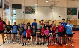 stoją w sali gimnastycznej osoby dorosłe, dzieci i młodzież, uczestnicy zajęć tenisa stołowego - Akademii Dekorglassu Działdowo