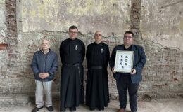 czterej mężczyźni Zenon Gajewski, o. Łukasz Andrzejewski CP, o. Massimo Parisi CP, Andrzej Rutecki w dawnym budynku KL Soldau
