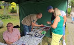 kadr z Jarmarku z 2024 roku, przedmioty na straganie i osoby oglądające