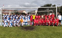 pamiątkowa fotografia młodych piłkarzy pozujących na tle bramki