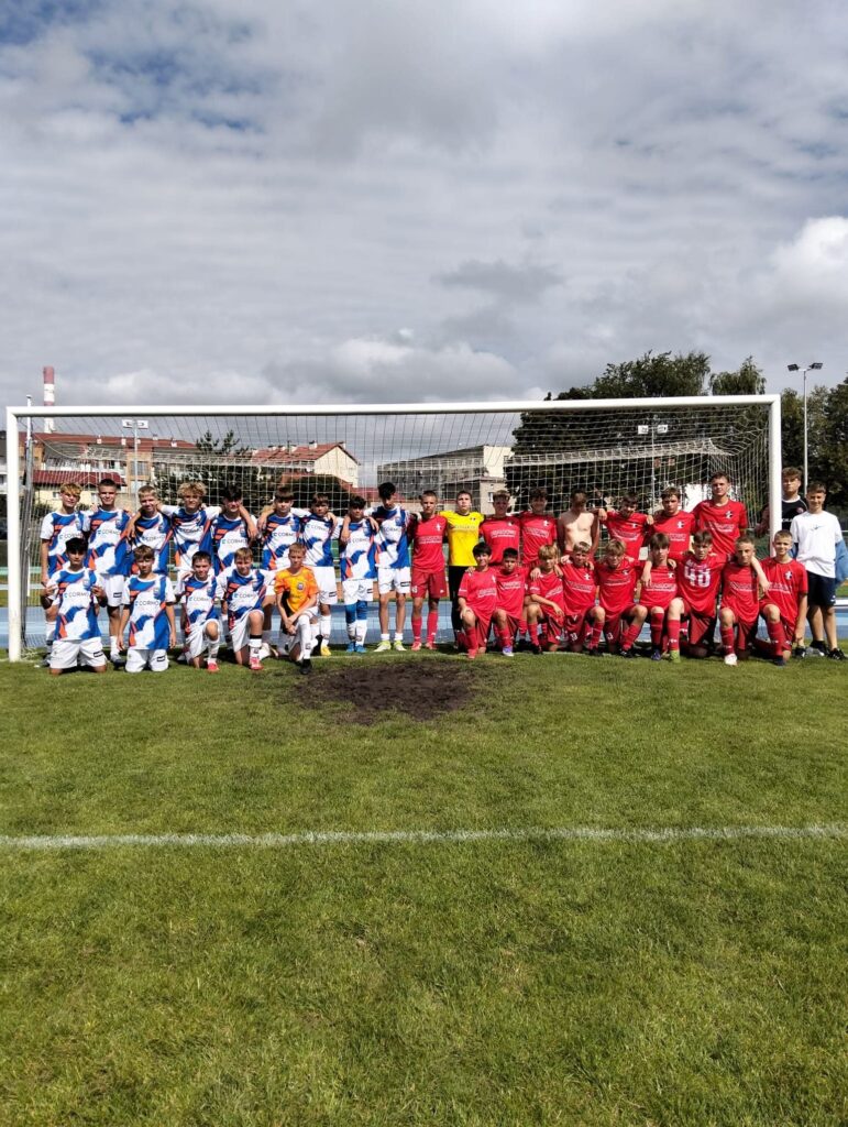 pamiątkowa fotografia młodych piłkarzy pozujących na tle bramki