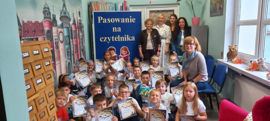 pamiątkowa fotografia uczniów z dyplomami, pań nauczycielek, pani dyrektor i pani bibliotekarki w Szkole Podstawowej nr 3 w Działdowie