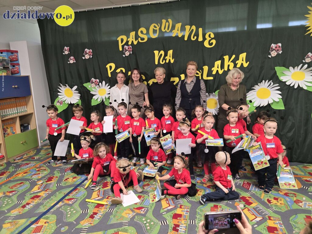 "Biedronki" pasowane na przedszkolaków pamiątkowa fotografia dzieci, nauczycielek i wiceburmistrz w sali przedszkolnej