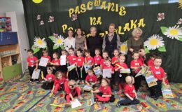 pamiątkowa fotografia dzieci, nauczycielek i wiceburmistrz w sali przedszkolnej