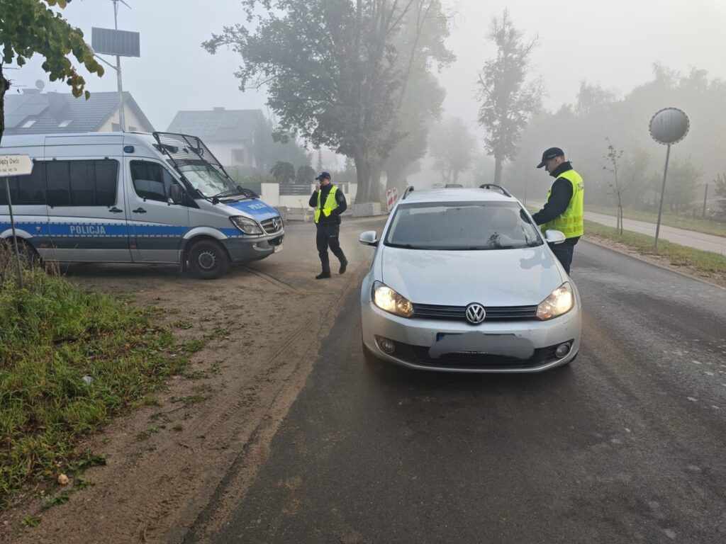 "działania trzeźwość", widać dwóch policjantów, kontrolowany pojazd i radiowóz policyjny / fot. policja