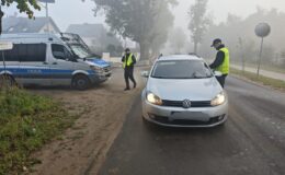 "działania trzeźwość", widać dwóch policjantów, kontrolowany pojazd i radiowóz policyjny / fot. policja