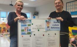 panie nauczycielki przy tablicy z hasłami Planu Daltońskiego