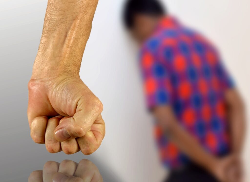 pięść, w tle rozmyta sylwetka osoby