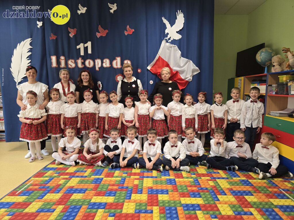 Uroczysta akademia z okazji Święta Niepodległości w Przedszkolu nr 5 pamiątkowe zdjęcie występujących przedszkolaków wraz panami nauczycielkami, wicedyrektor Sylwią Lipką-Pławską i wiceburmistrz Izabelą Sokolnicką