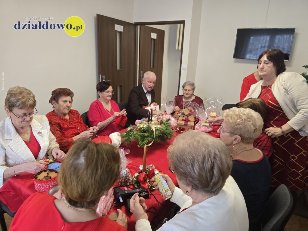 seniorzy siedzą, przygotowują przedmioty na kiermasz charytatywny