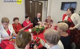 seniorzy siedzą, przygotowują przedmioty na kiermasz charytatywny