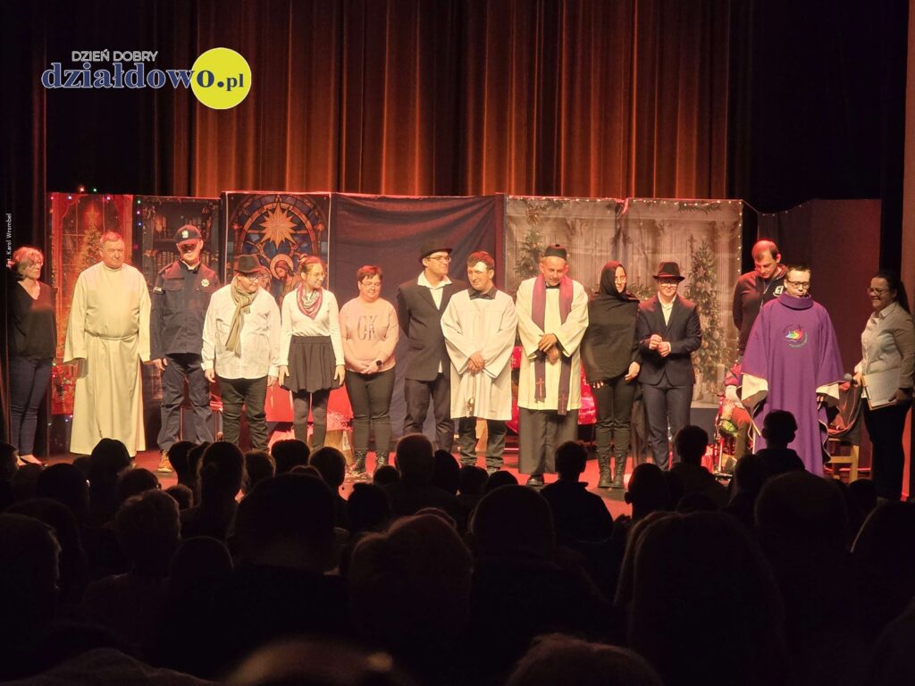 na scenie stoi grupa osób, kobiety i mężczyźni