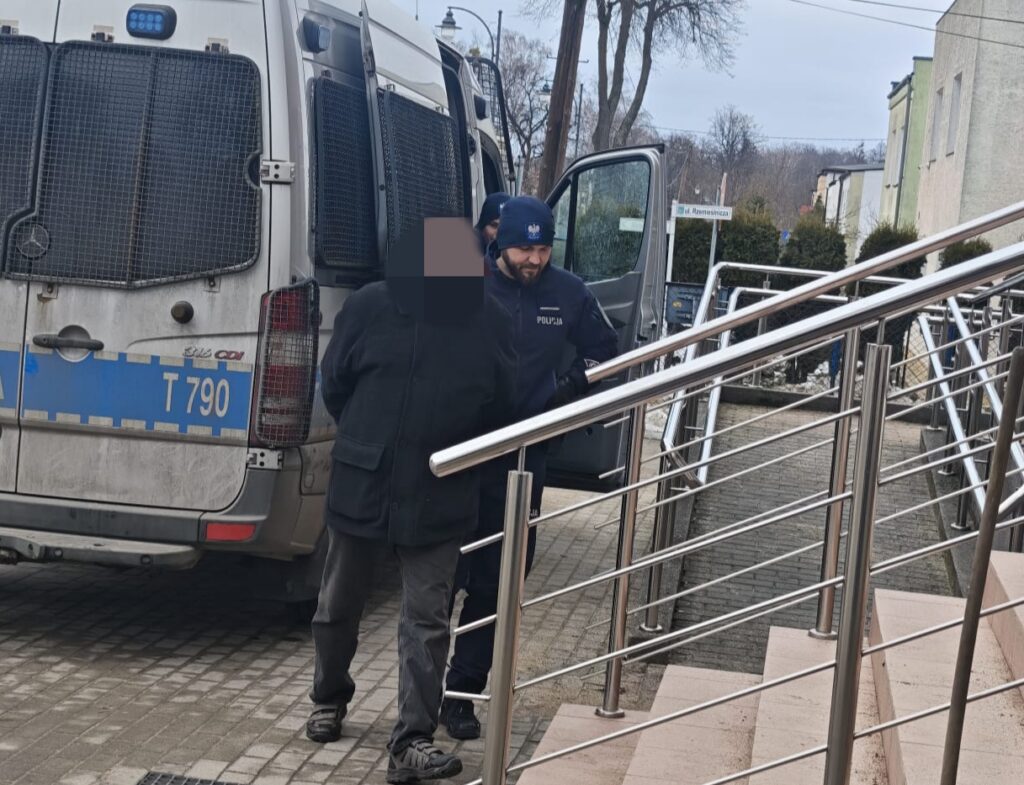 widać policjanta prowadzącego zatrzymanego / fot. policja