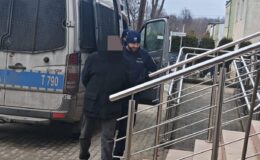 widać policjanta prowadzącego zatrzymanego / fot. policja