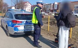 policjant, policyjny radiowóz i osoba stojąca z hulajnogą / fot. policja