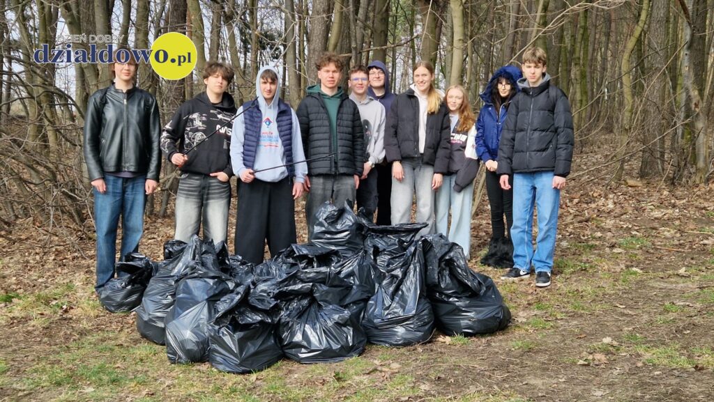 młodzież, dziewczęta i chłopcy, przed nimi worki pełne śmieci