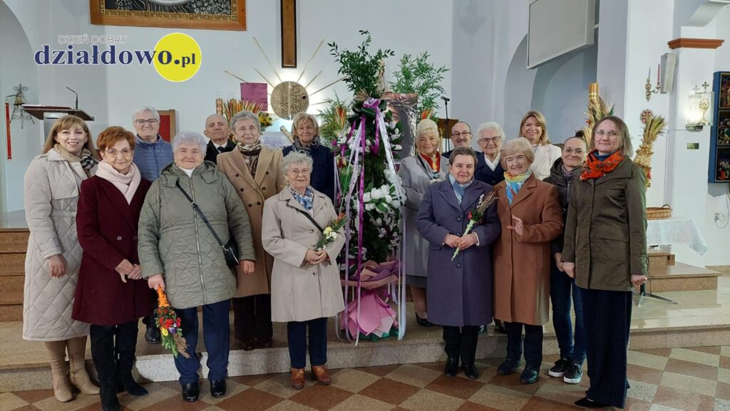 seniorzy pozują z własnoręcznie wykonaną palmą wielkanocną przy ołtarzu w kościele pw. Podwyższenia Krzyża Świętego w Działdowie