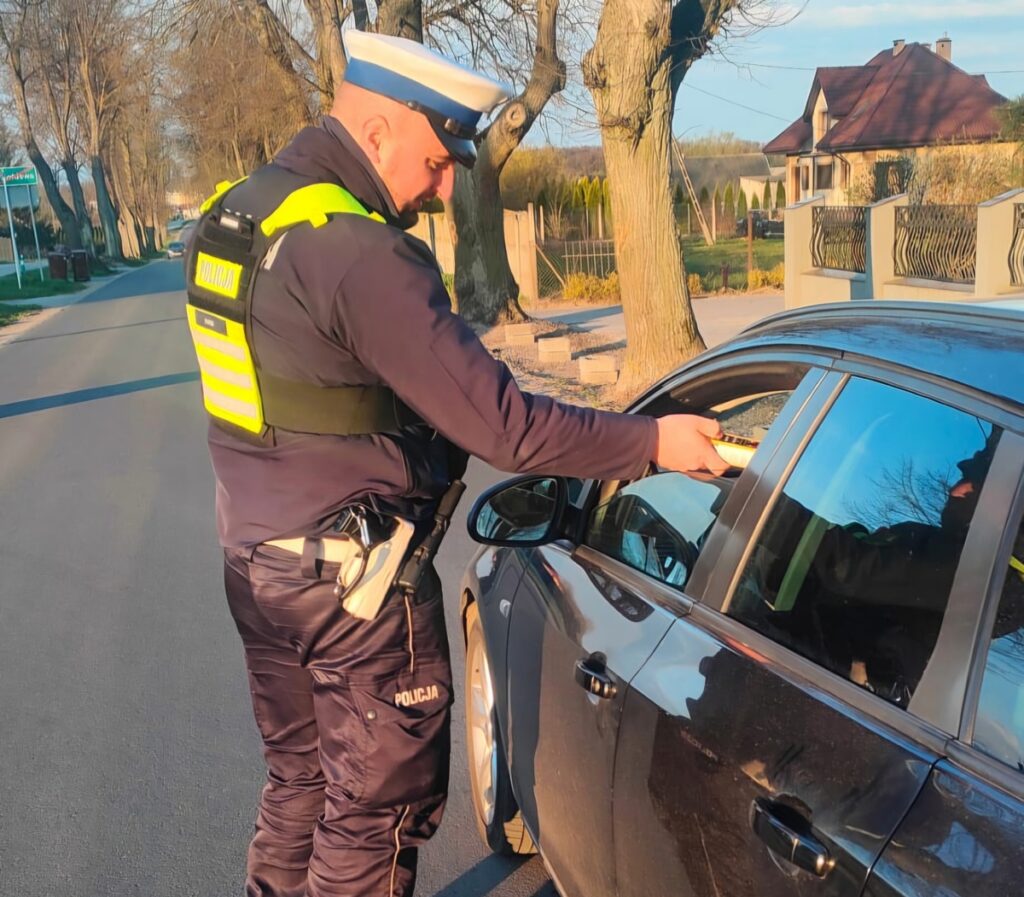 policjant bada alkomatem kierowcę samochodu /fot.policja
