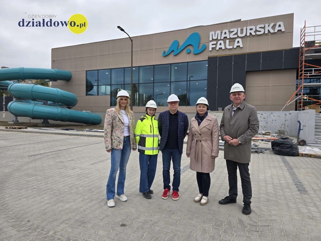 grupa osób, kobiety i mężczyźni przed budynkiem basenu w Działdowie