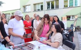 widać grupę osób, a poetka Joanna Śliwka wręcza egzemplarze swojej książki / fot. Jadwiga Smółka