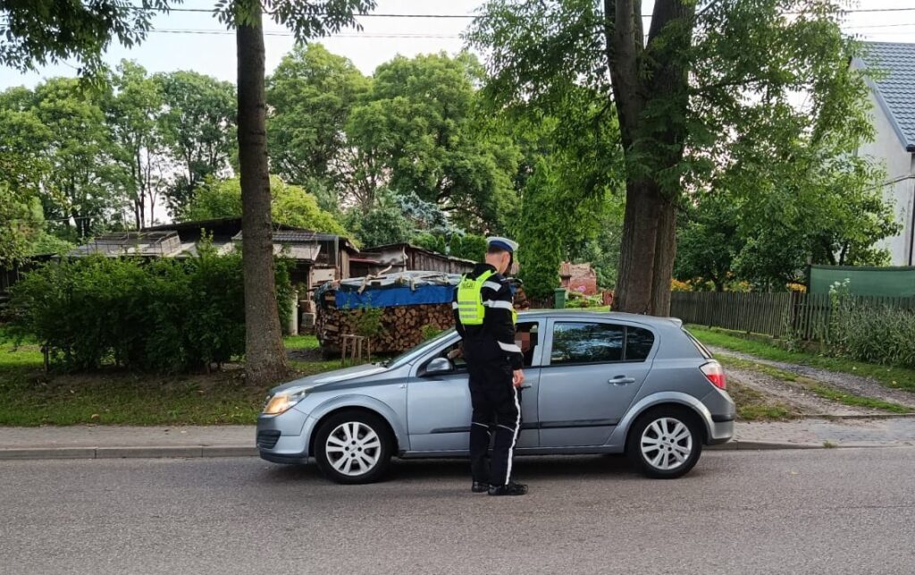 policjant badający stan trzeźwości kierowcy w samochodzie fot. policja