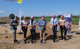grupa osób stojąca na miejscu inwestycji, gdzie powstanie blok w ramach Społecznej Inicjatywy Mieszkaniowej KZN Warmia i Mazury