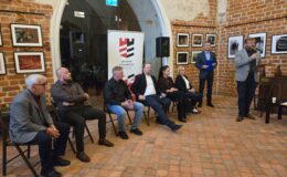 prowadzący spotkanie Piotr Kozikowski i artyści fotograficy w kaplicy zamkowej Muzeum Pogranicza w Działdowie