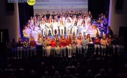 na scenie miejskiego Doku Kultury siedzą chóry, dzieci, młodzież i dorośli