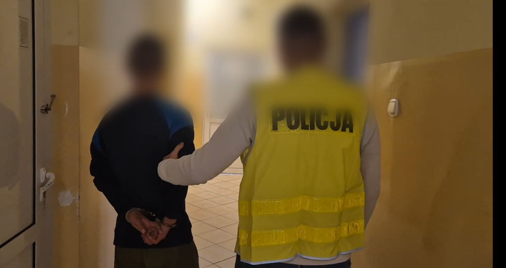 policjant podczas doprowadzenia osoby zatrzymanej