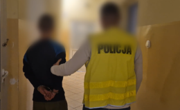 policjant podczas doprowadzenia osoby zatrzymanej