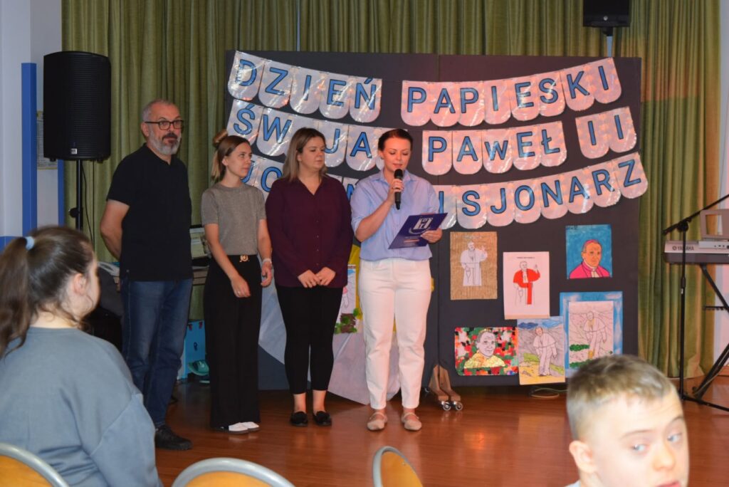 trzy kobiety i mężczyzna podczas prezentacji związanej z Dniem Papieskim obchodzonym w placówce Polskiego Stowarzyszenia na rzecz Osób z Niepełnosprawnością Intelektualną Koło w Działdowie / fot. archiwum PSONI