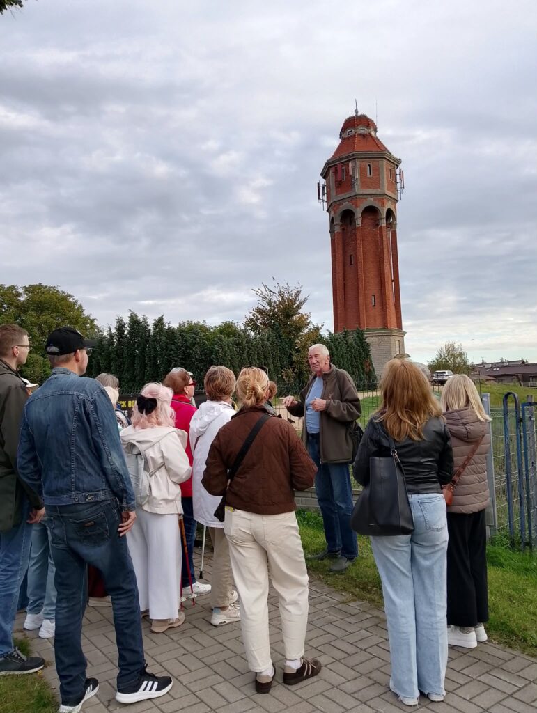grupa uczestników spacerku po Działdowie z przewodnikiem Marianem Odachowskim